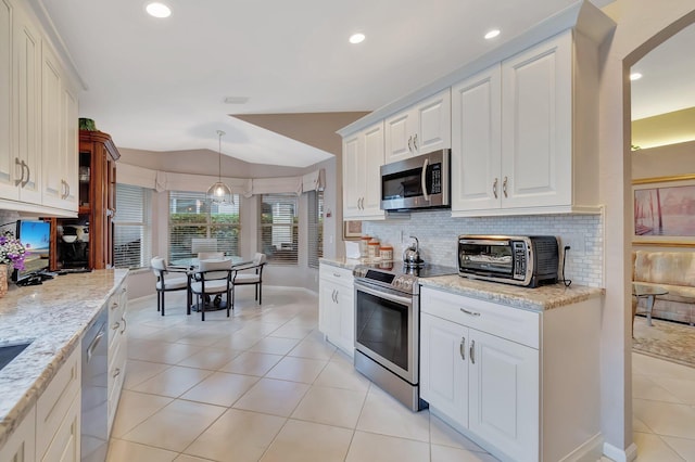 7714 Las Cruces Ct, Boynton Beach, FL 33437 - kitchen with stainless steel appliances, lofted ceiling, light tile patterned flooring, decorative backsplash, and light stone countertops