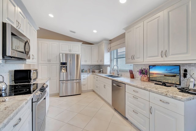 7714 Las Cruces Ct, Boynton Beach, FL 33437 - kitchen featuring stainless steel appliances, lofted ceiling, a sink, decorative backsplash, and white cabinets