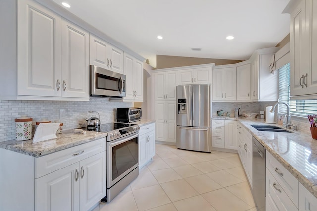 7714 Las Cruces Ct, Boynton Beach, FL 33437 - kitchen with stainless steel appliances, a sink, lofted ceiling, decorative backsplash, and white cabinets