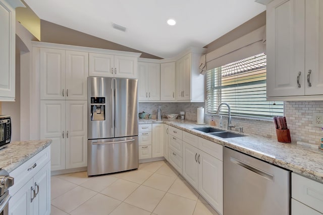 7714 Las Cruces Ct, Boynton Beach, FL 33437 - kitchen featuring stainless steel appliances, a sink, lofted ceiling, decorative backsplash, and white cabinetry