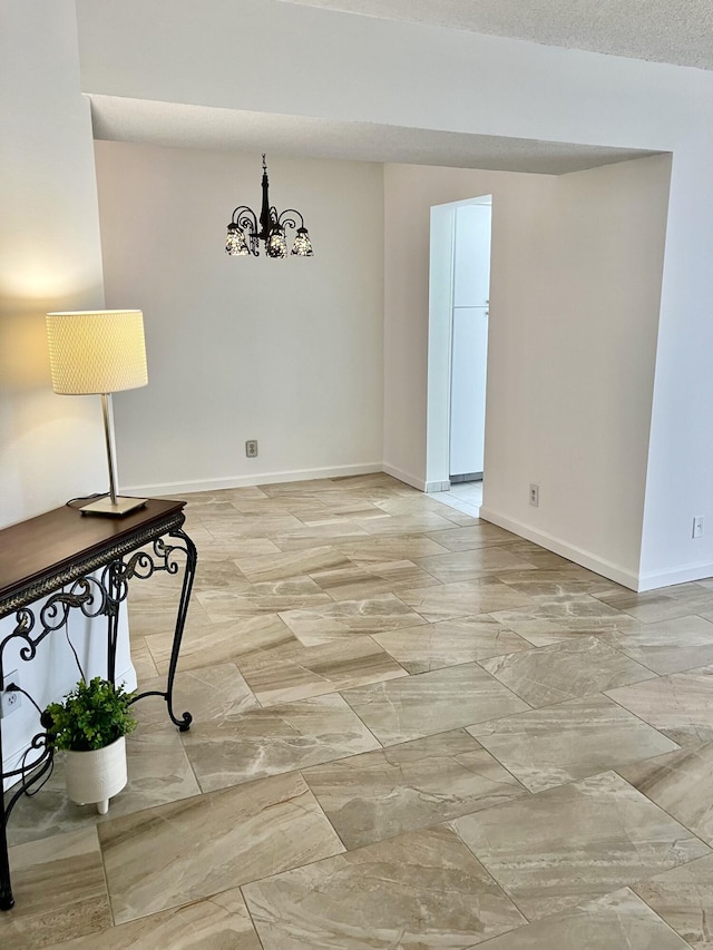 3590 Via Poinciana Unit 303, Lake Worth, FL 33467 - empty room featuring a chandelier and light marble finish floors