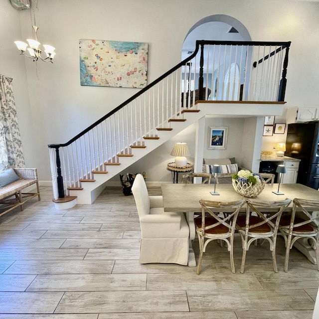 470 S Mars Way NE, Juno Beach, FL 33408 - dining area with stairway, light wood-style flooring, a chandelier, and a high ceiling