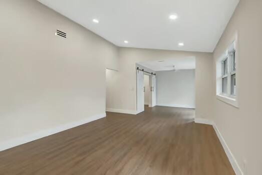 8914 Windtree St, Boca Raton, FL 33496 - unfurnished room with a barn door, baseboards, wood finished floors, and recessed lighting