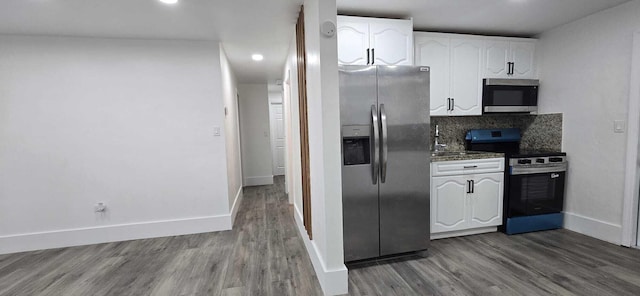 1510 S 23rd Ave, Hollywood, FL 33020 - kitchen with stainless steel appliances, white cabinets, wood finished floors, baseboards, and decorative backsplash
