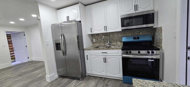 1510 S 23rd Ave, Hollywood, FL 33020 - kitchen with stainless steel appliances, a sink, light wood-style floors, white cabinetry, and recessed lighting