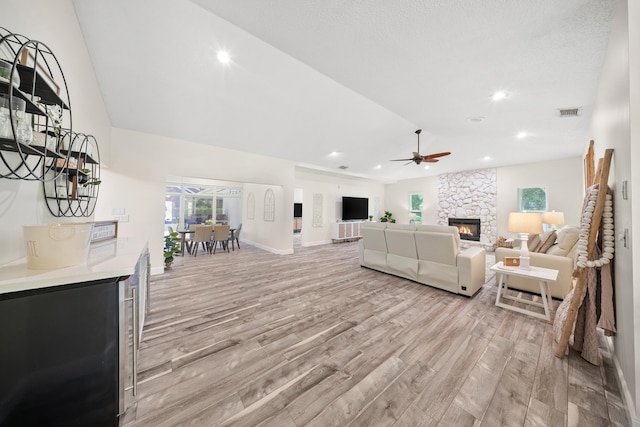 7903 Plantation Lakes Dr NW, Port Saint Lucie, FL 34986 - living room with light wood-style flooring, a stone fireplace, healthy amount of natural light, a ceiling fan, and recessed lighting