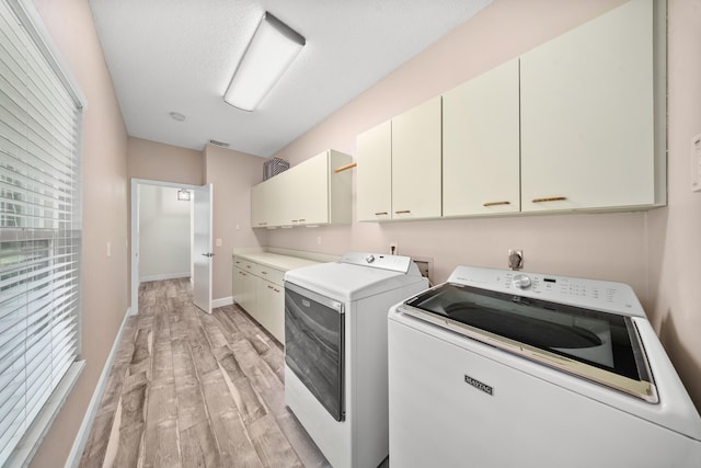 7903 Plantation Lakes Dr NW, Port Saint Lucie, FL 34986 - laundry area featuring cabinet space, light wood-style flooring, washer and dryer, and baseboards