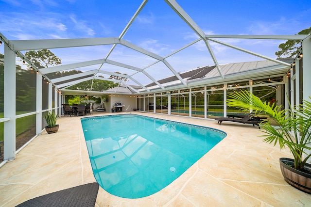 7903 Plantation Lakes Dr NW, Port Saint Lucie, FL 34986 - swimming pool featuring a patio area, glass enclosure, area for grilling, and outdoor dining space
