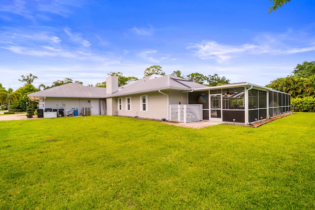 7903 Plantation Lakes Dr NW, Port Saint Lucie, FL 34986 - rear view of property with a sunroom, a yard, a chimney, metal roof, and stucco siding