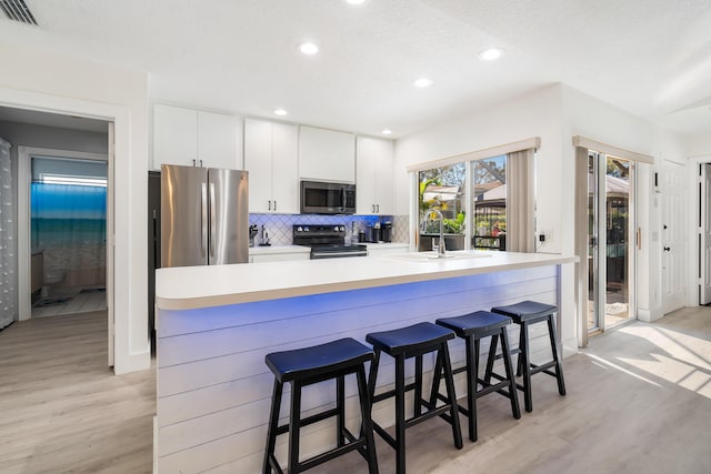 9132 Sun Terrace Cir Unit D, Palm Beach Gardens, FL 33403 - kitchen with appliances with stainless steel finishes, a sink, light wood-type flooring, decorative backsplash, and recessed lighting