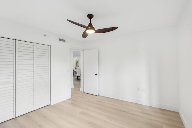 1601 Marina Isle Way Unit 101, Jupiter, FL 33477 - unfurnished bedroom featuring light wood-style flooring, baseboards, a closet, and a ceiling fan