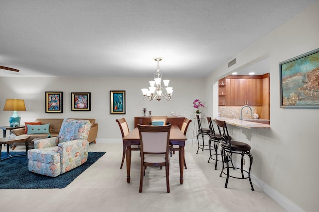 9628 Pavarotti Ter Unit 101, Boynton Beach, FL 33437 - dining room with a chandelier, baseboards, a ceiling fan, and a textured ceiling