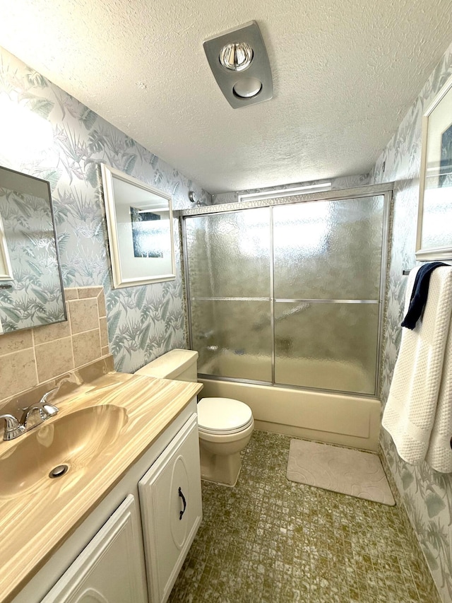 709 Lori Dr Unit 301, Palm Springs, FL 33461 - full bath featuring wallpapered walls, vanity, combined bath / shower with glass door, a textured ceiling, and toilet