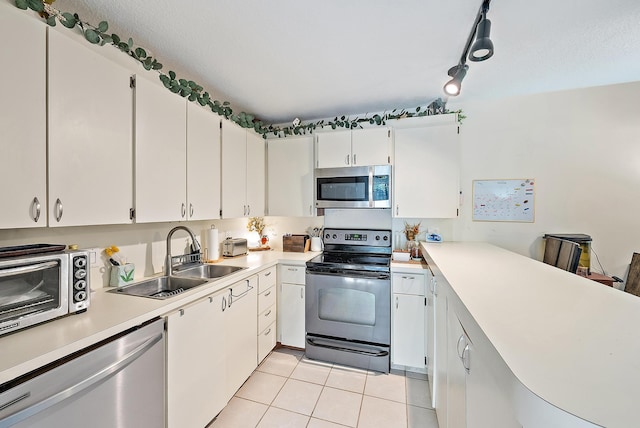 506 5th Ter, Palm Beach Gardens, FL 33418 - kitchen featuring stainless steel appliances, a sink, light tile patterned floors, light countertops, and white cabinetry