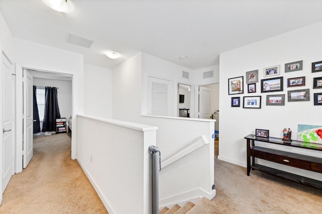 6143 Wildfire Way, West Palm Beach, FL 33415 - hallway with an upstairs landing, light carpet, and baseboards