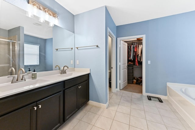 6143 Wildfire Way, West Palm Beach, FL 33415 - bathroom with double vanity, a shower stall, a walk in closet, tile patterned flooring, and a garden tub