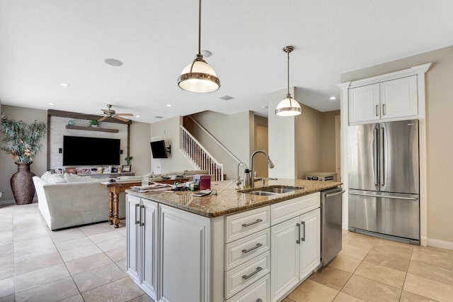 101 Saint Pierre Way, Jupiter, FL 33458 - kitchen with stainless steel appliances, a sink, a ceiling fan, light stone counters, and light tile patterned floors