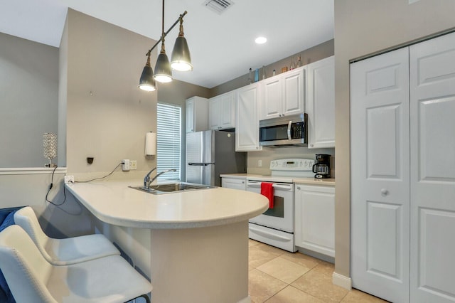 101 Saint Pierre Way, Jupiter, FL 33458 - kitchen with stainless steel appliances, a sink, white cabinetry, a peninsula, and light tile patterned floors