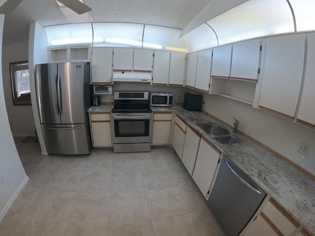 1713 Mariners Cv Unit 7C, Fort Pierce, FL 34950 - kitchen featuring stainless steel appliances, a sink, under cabinet range hood, baseboards, and light tile patterned floors