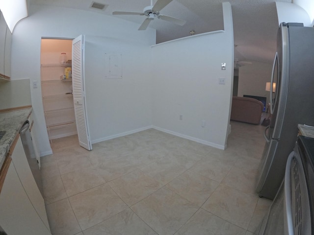 1713 Mariners Cv Unit 7C, Fort Pierce, FL 34950 - kitchen featuring ceiling fan, vaulted ceiling, light tile patterned flooring, light stone countertops, and freestanding refrigerator
