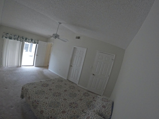 1713 Mariners Cv Unit 7C, Fort Pierce, FL 34950 - unfurnished bedroom featuring light carpet, vaulted ceiling, a textured ceiling, ceiling fan, and baseboards