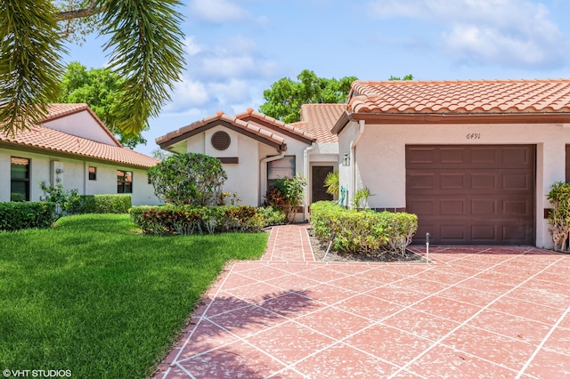 6491 Royal Manor Cir, Delray Beach, FL 33484 - mediterranean / spanish home with stucco siding, an attached garage, a tile roof, a front yard, and concrete driveway