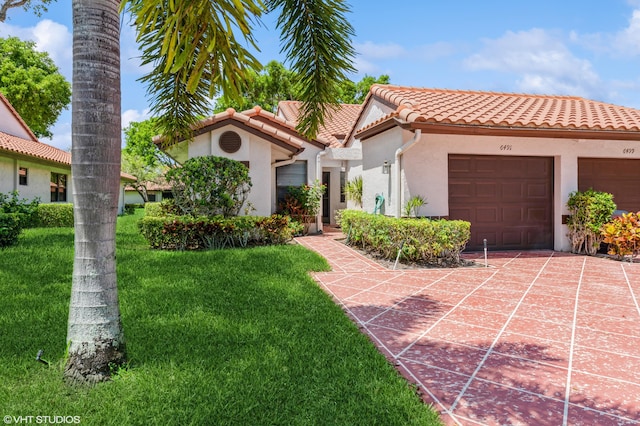 6491 Royal Manor Cir, Delray Beach, FL 33484 - mediterranean / spanish-style home featuring stucco siding, a front yard, a tiled roof, a garage, and concrete driveway