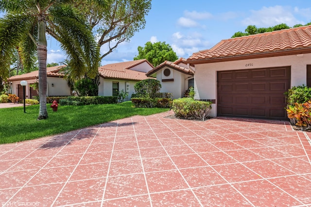 6491 Royal Manor Cir, Delray Beach, FL 33484 - mediterranean / spanish-style house featuring stucco siding, a tiled roof, a front yard, and an attached garage