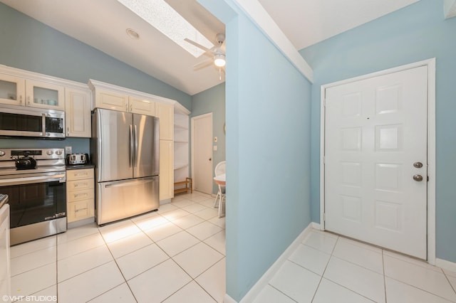 6491 Royal Manor Cir, Delray Beach, FL 33484 - kitchen with appliances with stainless steel finishes, lofted ceiling, a ceiling fan, a skylight, and light tile patterned floors