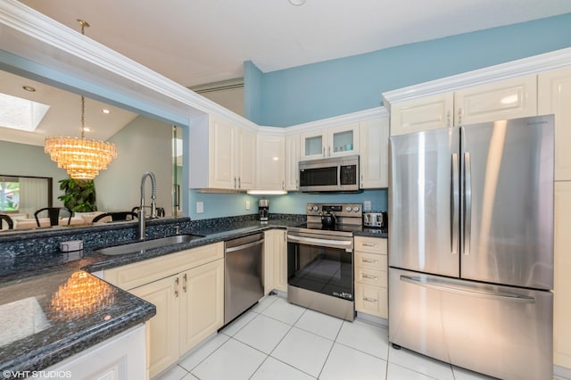 6491 Royal Manor Cir, Delray Beach, FL 33484 - kitchen with stainless steel appliances, a sink, a chandelier, light tile patterned floors, and dark stone countertops