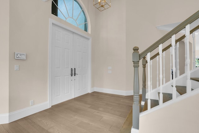 6688 Duckweed Rd, Lake Worth, FL 33449 - foyer entrance with wood finished floors, a chandelier, stairs, baseboards, and a high ceiling