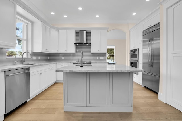 6688 Duckweed Rd, Lake Worth, FL 33449 - kitchen featuring stainless steel appliances, wall chimney exhaust hood, a sink, a center island with sink, and decorative backsplash