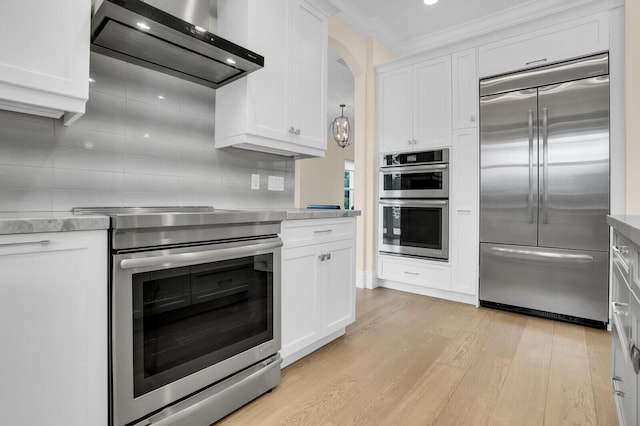 6688 Duckweed Rd, Lake Worth, FL 33449 - kitchen with appliances with stainless steel finishes, ventilation hood, light wood-style flooring, white cabinetry, and ornamental molding