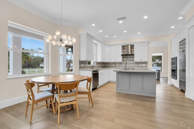 6688 Duckweed Rd, Lake Worth, FL 33449 - kitchen featuring appliances with stainless steel finishes, a sink, wall chimney range hood, a center island with sink, and decorative backsplash