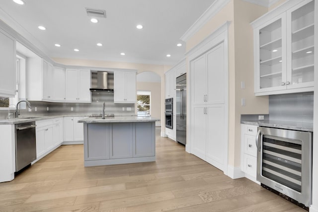 6688 Duckweed Rd, Lake Worth, FL 33449 - kitchen featuring wine cooler, a sink, appliances with stainless steel finishes, wall chimney exhaust hood, and ornamental molding