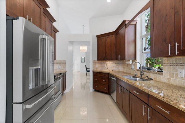 6607 NW 25th Way, Boca Raton, FL 33496 - kitchen featuring appliances with stainless steel finishes, light stone counters, light tile patterned flooring, a sink, and tasteful backsplash