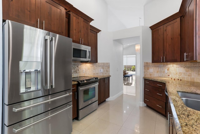 6607 NW 25th Way, Boca Raton, FL 33496 - kitchen featuring appliances with stainless steel finishes, light stone counters, backsplash, light tile patterned floors, and baseboards