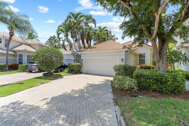 6607 NW 25th Way, Boca Raton, FL 33496 - view of front of home featuring a tile roof, stucco siding, a garage, and decorative driveway