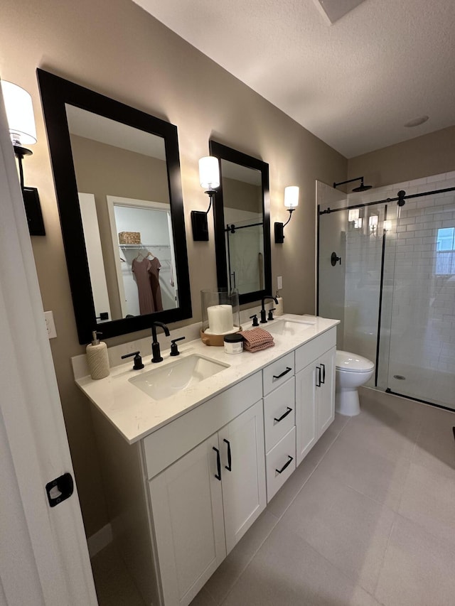 306 Silver Sands Ln Unit 17, Fort Pierce, FL 34945 - bathroom with a shower stall, double vanity, toilet, a textured ceiling, and tile patterned flooring