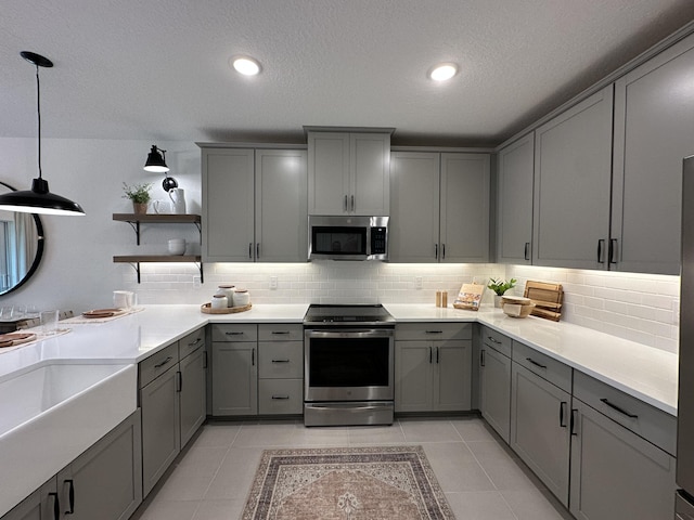 306 Silver Sands Ln Unit 17, Fort Pierce, FL 34945 - kitchen with appliances with stainless steel finishes, gray cabinetry, open shelves, a textured ceiling, and recessed lighting