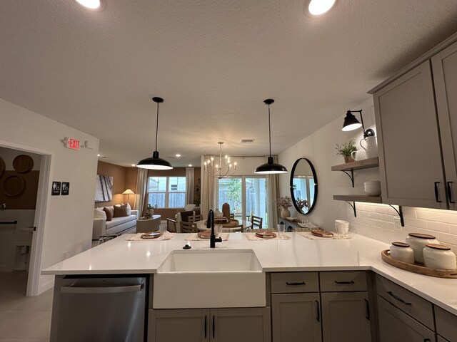 306 Silver Sands Ln Unit 17, Fort Pierce, FL 34945 - kitchen with dishwasher, gray cabinetry, a sink, open floor plan, and a peninsula