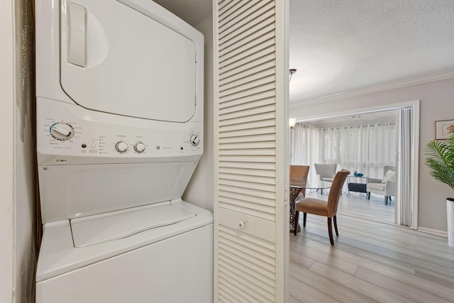 10116 46th Ave S Unit 488, Boynton Beach, FL 33436 - laundry room featuring estacked washer and dryer, light wood finished floors, crown molding, and a textured ceiling