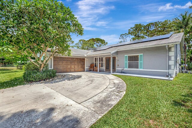 17495 40th Run N, Loxahatchee, FL 33470 - ranch-style house with stucco siding, a front lawn, a garage, and roof mounted solar panels