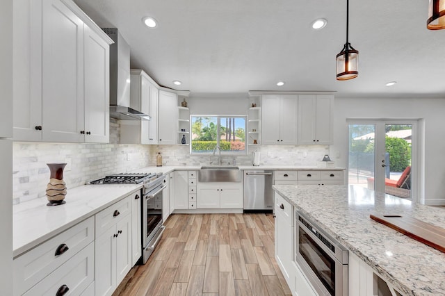 17495 40th Run N, Loxahatchee, FL 33470 - kitchen featuring appliances with stainless steel finishes, a sink, wall chimney range hood, open shelves, and healthy amount of natural light
