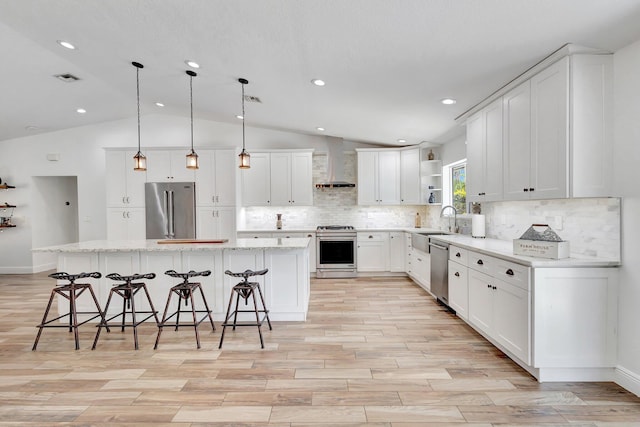 17495 40th Run N, Loxahatchee, FL 33470 - kitchen with stainless steel appliances, wall chimney exhaust hood, open shelves, vaulted ceiling, and light wood-type flooring