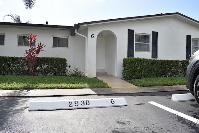 2930 Crosley Dr E Unit G, West Palm Beach, FL 33415 - view of front of house featuring stucco siding and uncovered parking