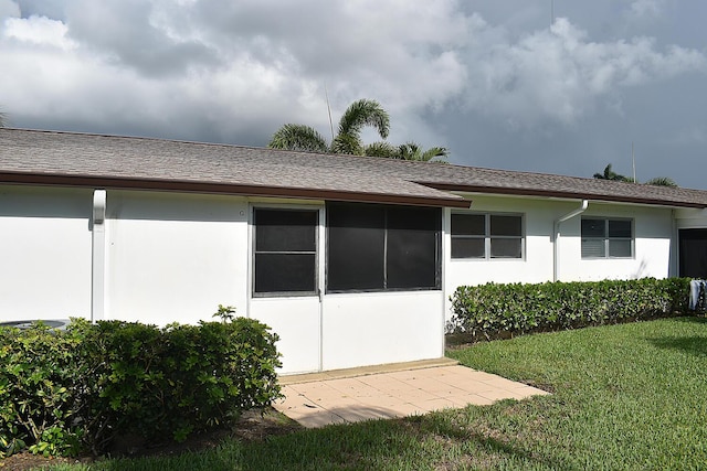 2930 Crosley Dr E Unit G, West Palm Beach, FL 33415 - rear view of house with stucco siding, a lawn, and a shingled roof