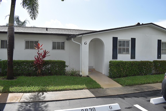 2930 Crosley Dr E Unit G, West Palm Beach, FL 33415 - ranch-style home with stucco siding, a front yard, and a shingled roof