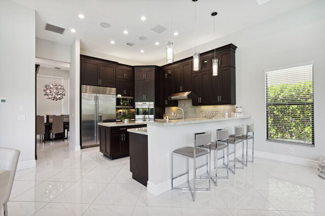 16770 Burlington Bristol Ln, Delray Beach, FL 33446 - kitchen featuring stainless steel appliances, light marble finish floors, light countertops, recessed lighting, and a peninsula