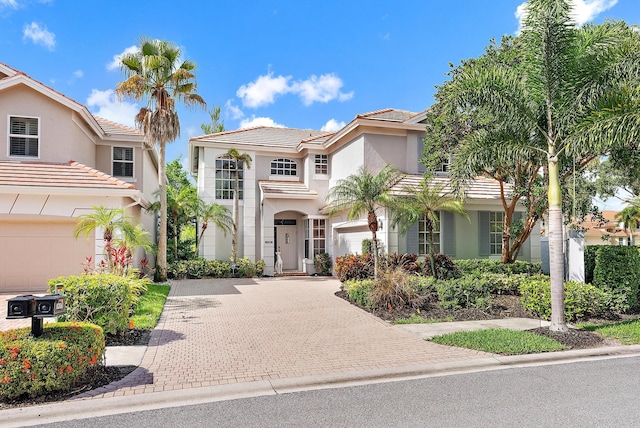 8208 Heritage Club Dr, West Palm Beach, FL 33412 - mediterranean / spanish home featuring stucco siding, decorative driveway, a tiled roof, and a garage